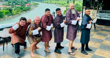 Several people wearing traditional Bhutanese gho robes.